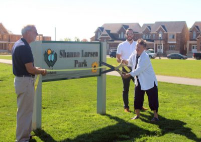 Lorna Larsen cuts the ribbon on Shanna Larsen Park sign